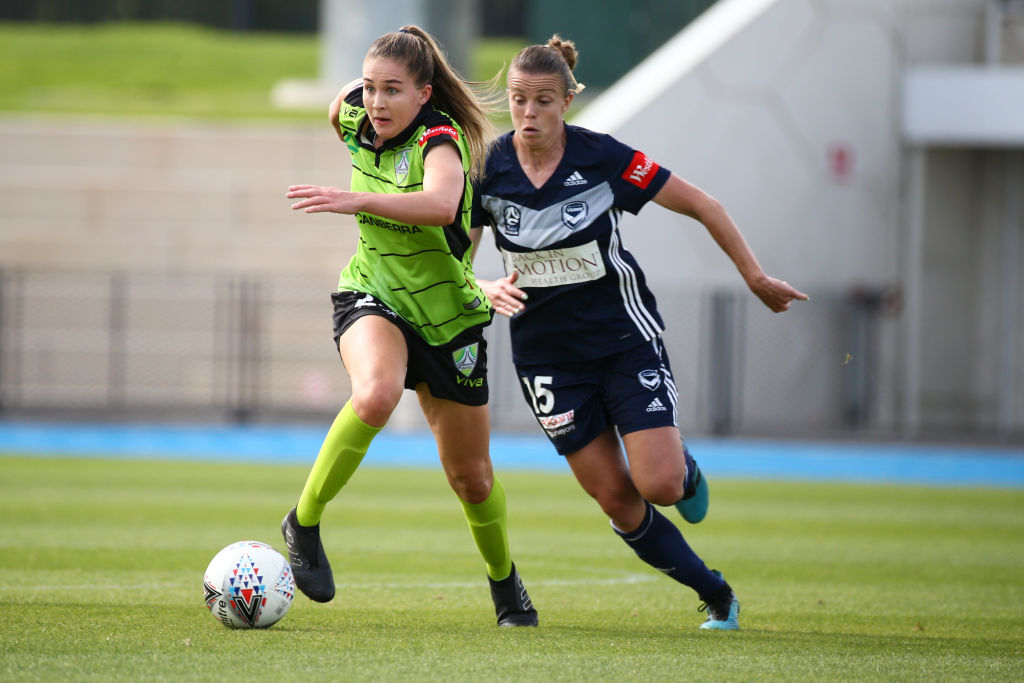 Aoife Colvill of Canberra United runs with the ball in front of Amy Jackson. 